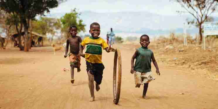 Children playing with a hoop on a rough track