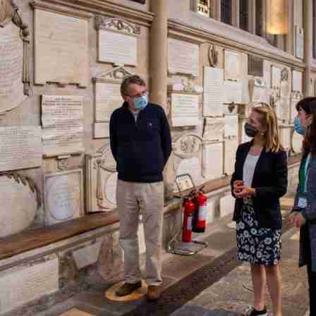 Rector of Bath Abbey Guy Bridgewater, Bath MP Wera Hobhouse and Polly Andrews, Learning Officer at Bath Abbey looking at the Abbey's memorials in the North transept