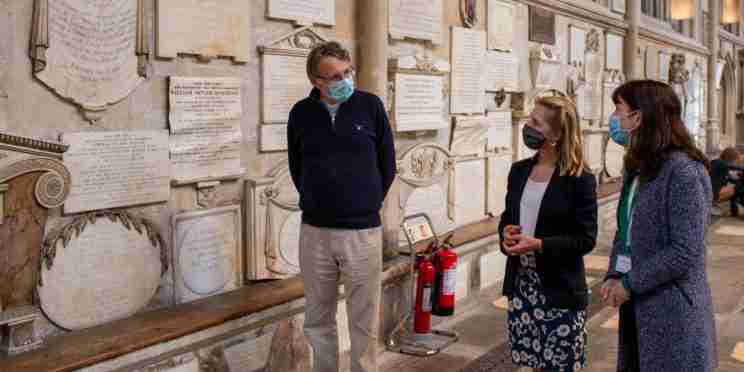 Rector of Bath Abbey Guy Bridgewater, Bath MP Wera Hobhouse and Polly Andrews, Learning Officer at Bath Abbey looking at the Abbey's memorials in the North transept