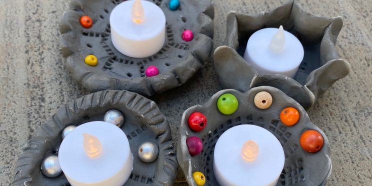 Decorated clay candle holder with a tealight