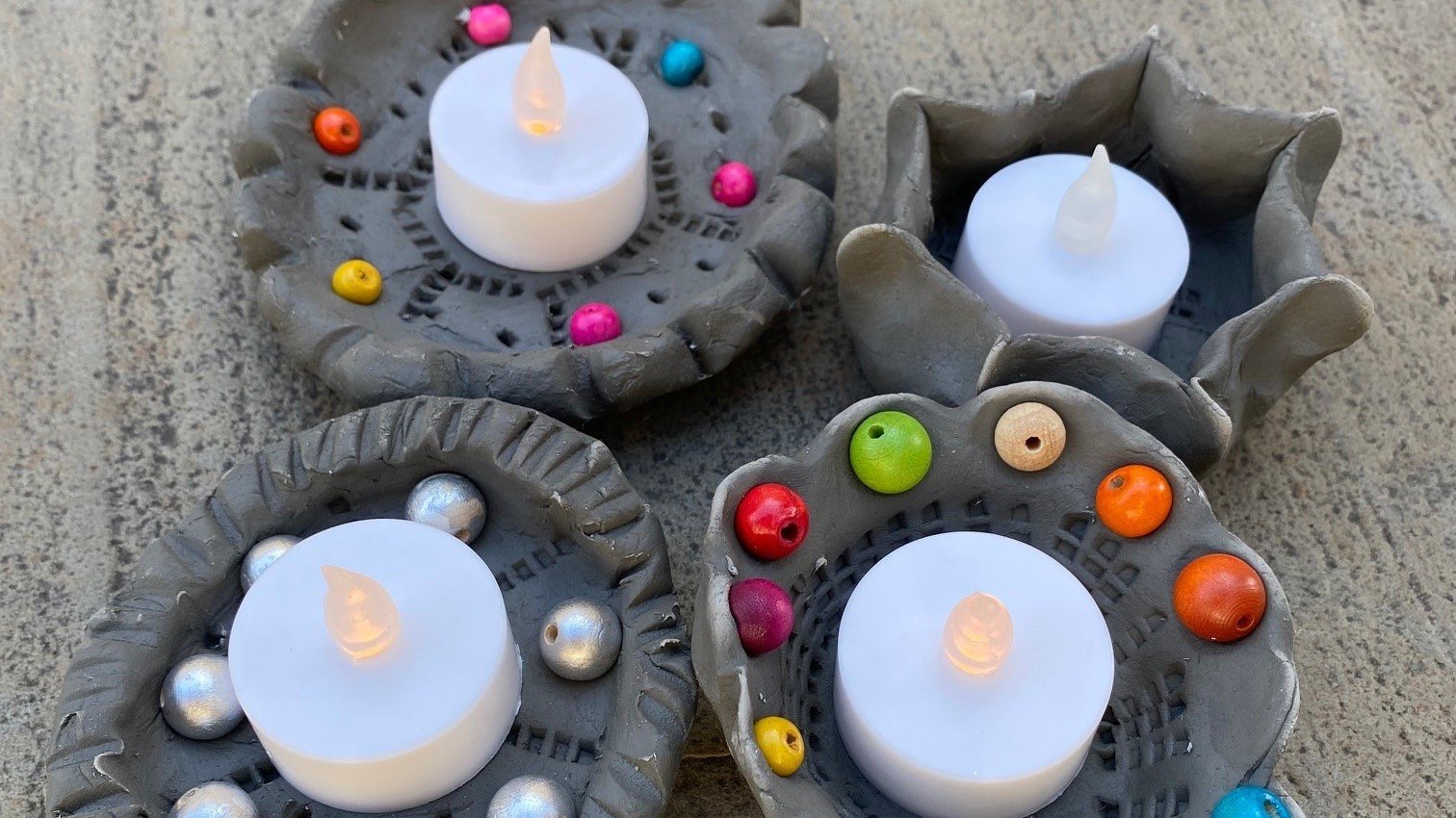 Decorated clay candle holder with a tealight